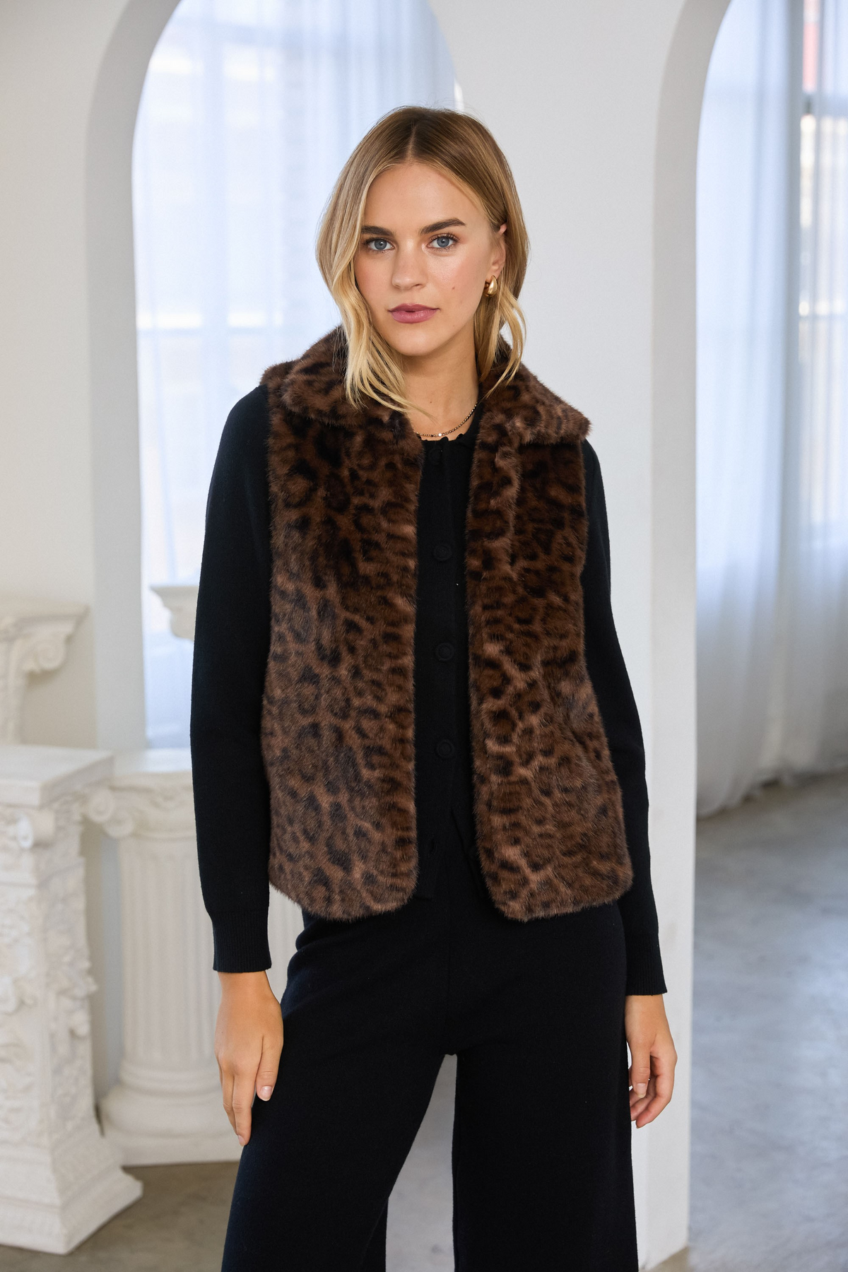 Woman wearing the Celeste Leopard Faux Fur Vest over a black long-sleeve top and matching pants.