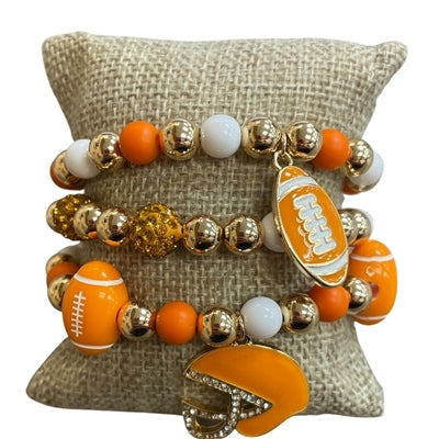 Three-piece football beaded stretch bracelet stack with orange, white, and gold beads and charms.