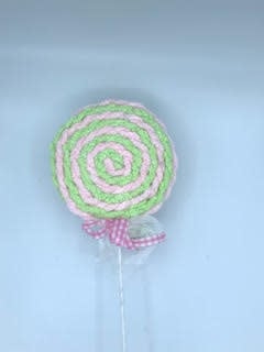 Pink and green fabric lollipop decoration with a spiral pattern and a gingham bow on the stem.