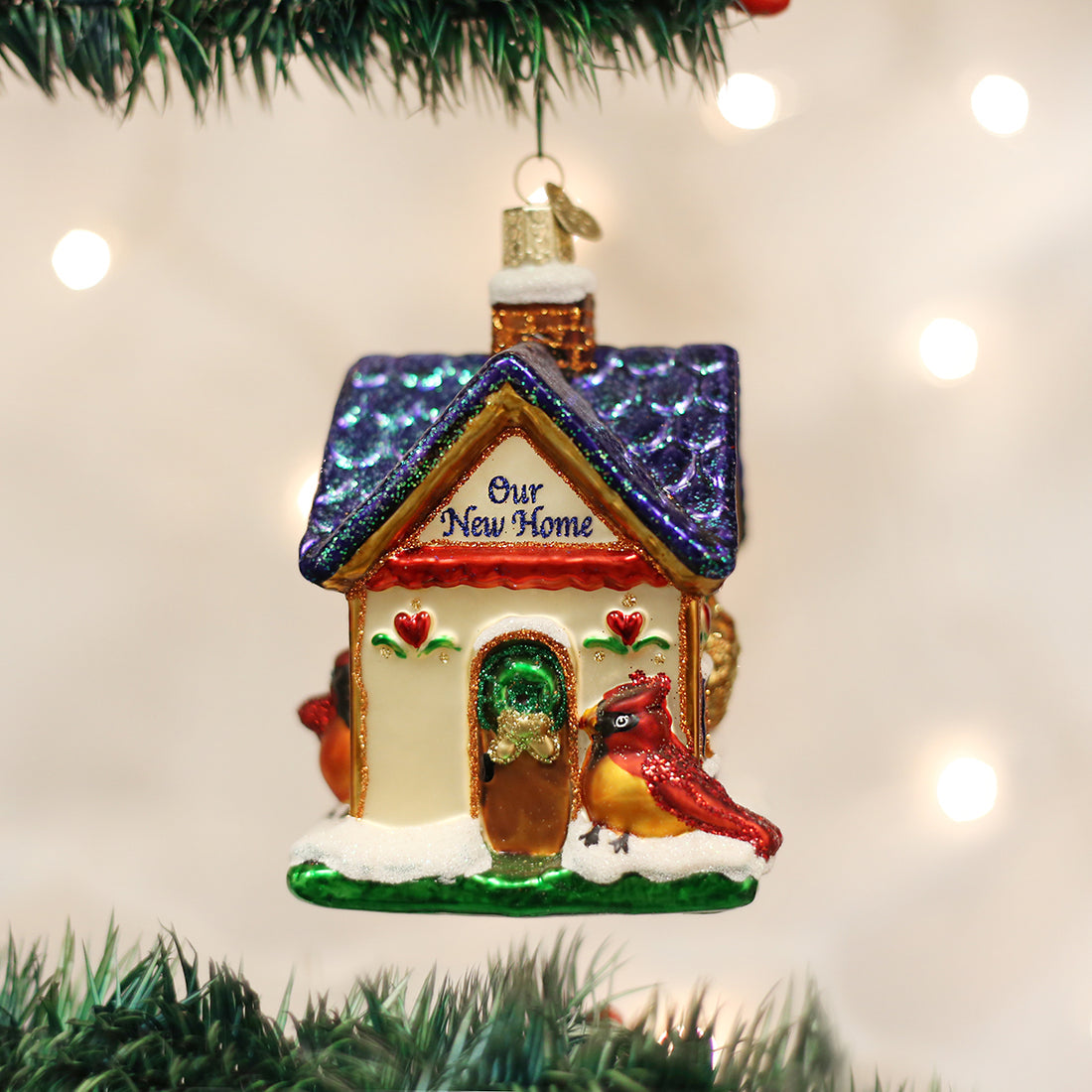 Glass house ornament with blue glitter roof, red cardinal, and "Our New Home" text.