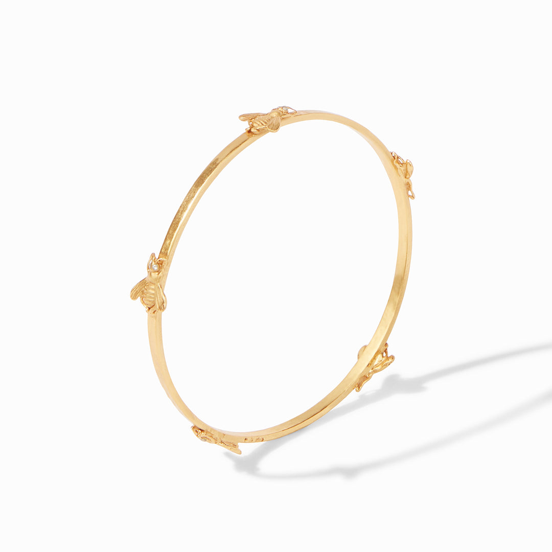 Gold bangle bracelet featuring five small bee charms evenly spaced around the band.