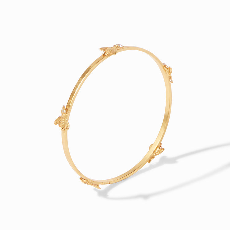 Gold bangle bracelet featuring five small bee charms evenly spaced around the band.