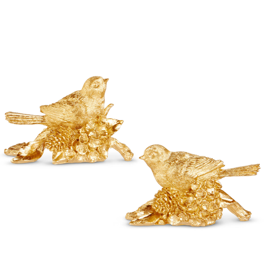 Two gold-finished resin bird figurines perched on pinecone and floral branches.