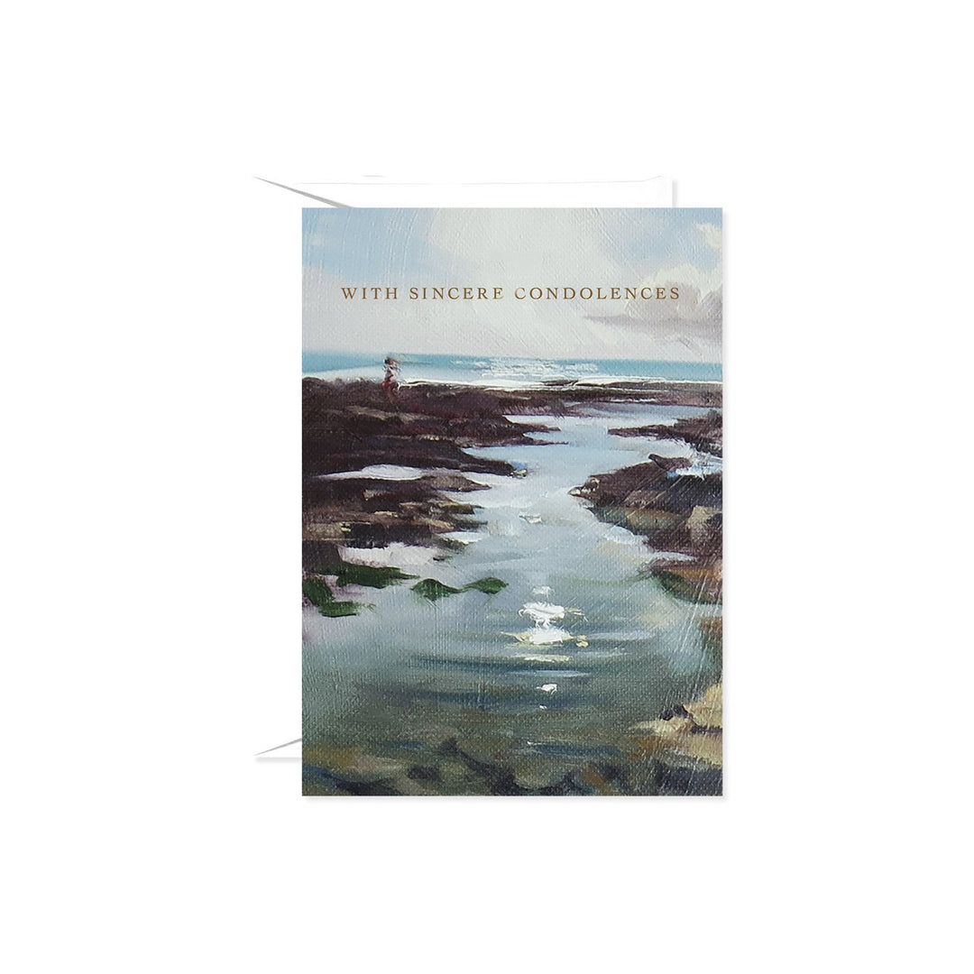 A condolence card featuring a serene beach scene painting with the text "WITH SINCERE CONDOLENCES" in gold lettering.