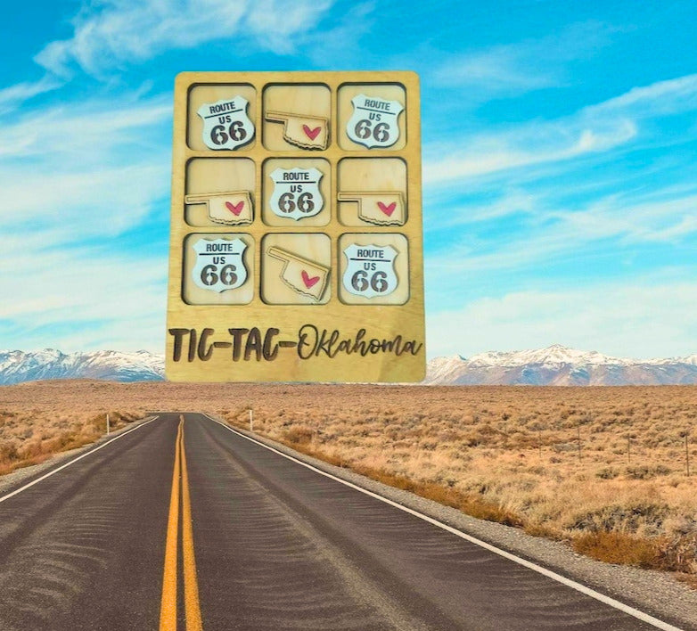 Wooden Oklahoma Tic-Tac-Toe board with Route 66 and state-shaped pieces over a desert road scene.