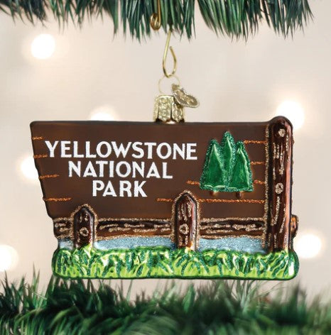 Glass Yellowstone National Park sign ornament hanging on a Christmas tree.