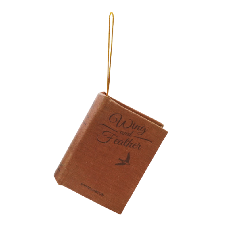 Brown fabric book ornament titled Wing and Feather by Emma Gibson with a gold hanging loop.