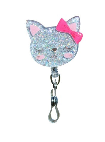 Glitterific badge reel with a black alligator clip holding a round glitter resin pin in pink and silver sparkles.