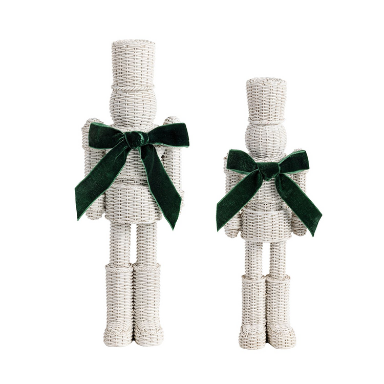 Two white hand-painted resin nutcrackers with a wicker-inspired texture and green velvet bows.