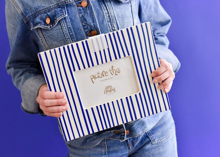 Person holding a Happy Everything Indigo Skinny Stripe Mini Rectangle Frame against a blue backdrop.