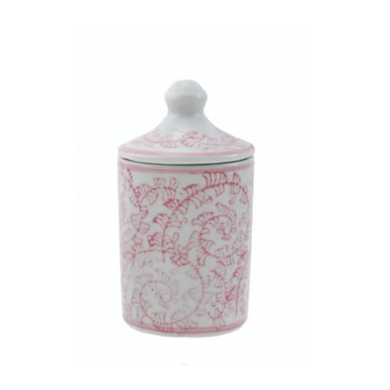 Hand-stamped pink stoneware spice jar with a lid and intricate vine pattern on a white background.