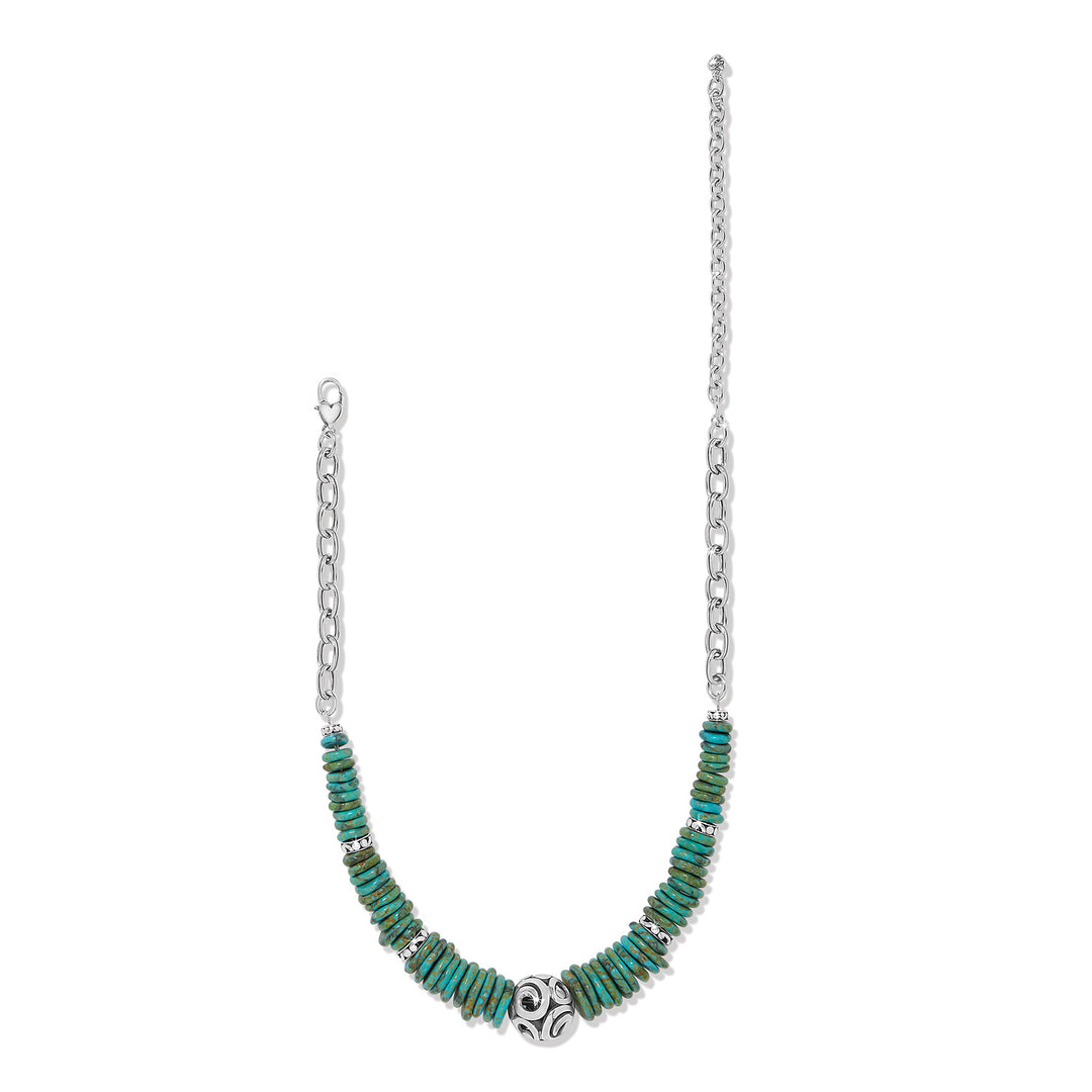 Silver-plated necklace with blue turquoise magnesite disc pendant on an adjustable chain.