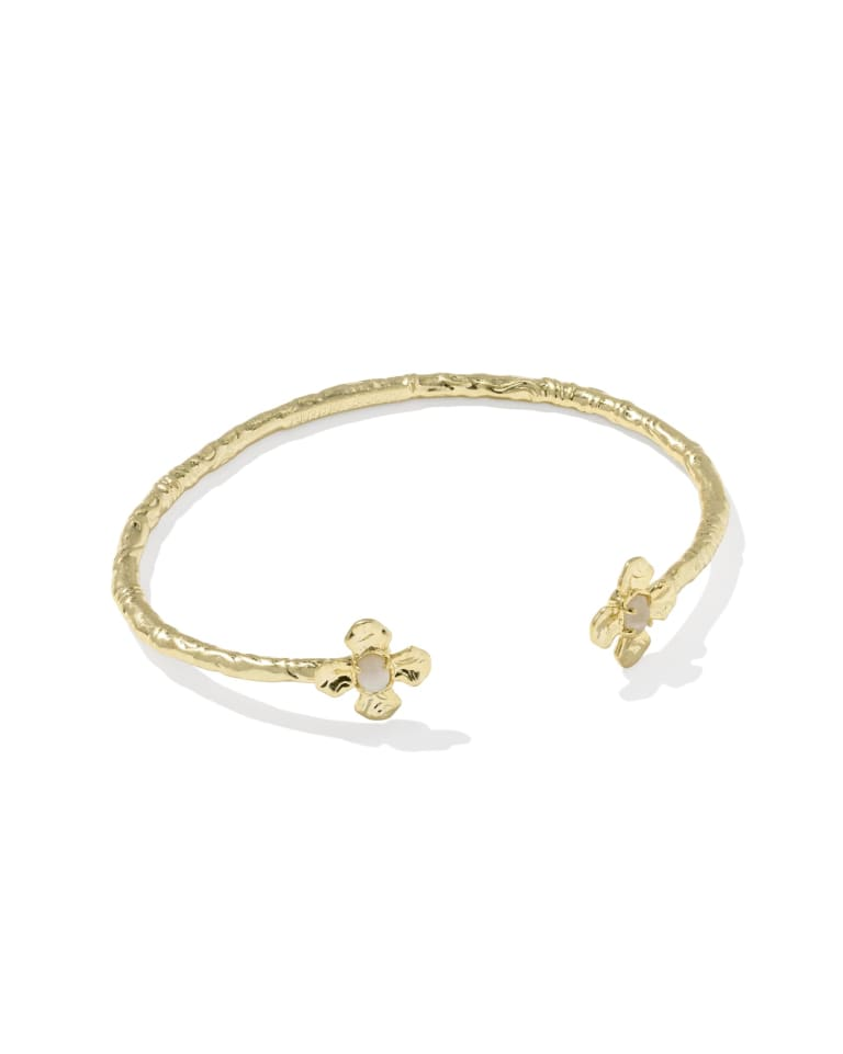 Gold textured cuff bracelet with two small flower-shaped ends featuring white stone centers.
