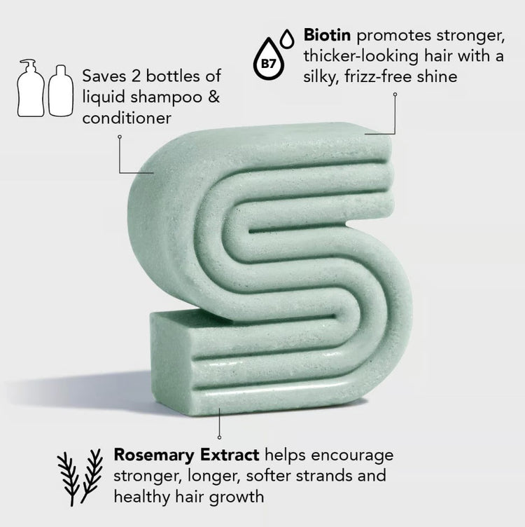 S-shaped green solid shampoo bar with text highlighting biotin, rosemary extract, and eco-savings.