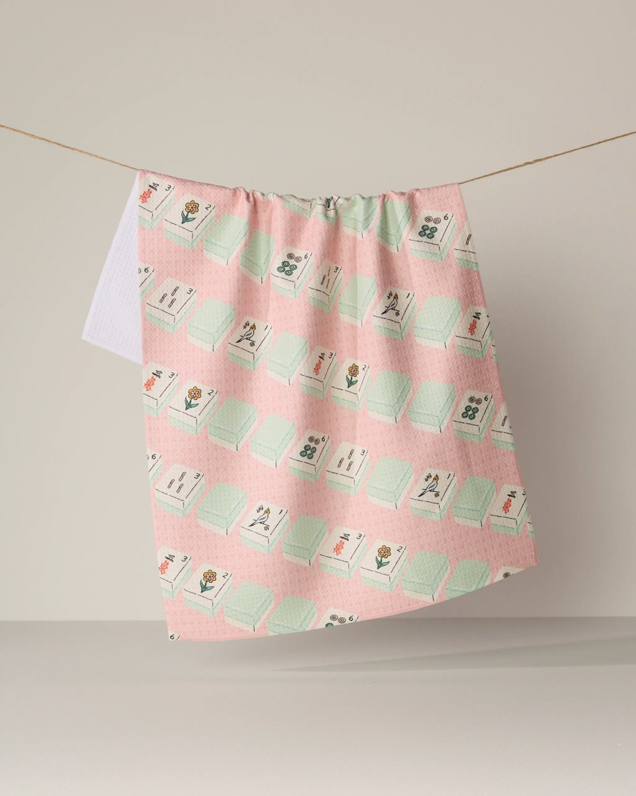 Pink Everyday Tea Towel with a mahjong tile pattern hanging on a clothesline.