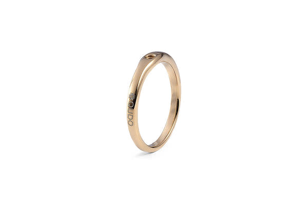 Fine gold ring with a subtle curve and engraved text on the side.