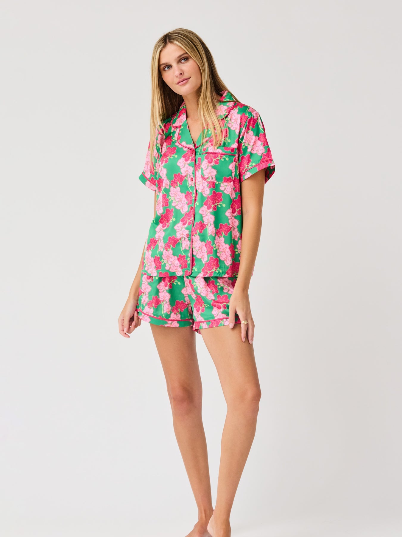 Woman wearing the Charlotte Pajama Short Set in a green and pink floral print satin fabric.
