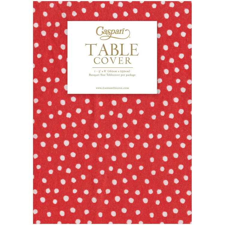 Red paper linen table cover with a white small polka dot pattern and Caspari branding.