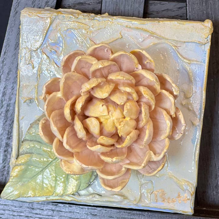 4x4 inch square clay artwork featuring a mum flower relief in earthy tones.