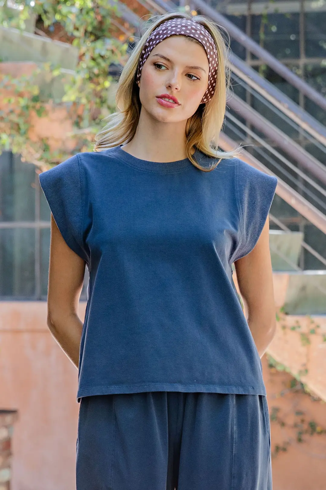 Woman wearing a navy blue Briella ribbed trim cap sleeve top with a relaxed silhouette.