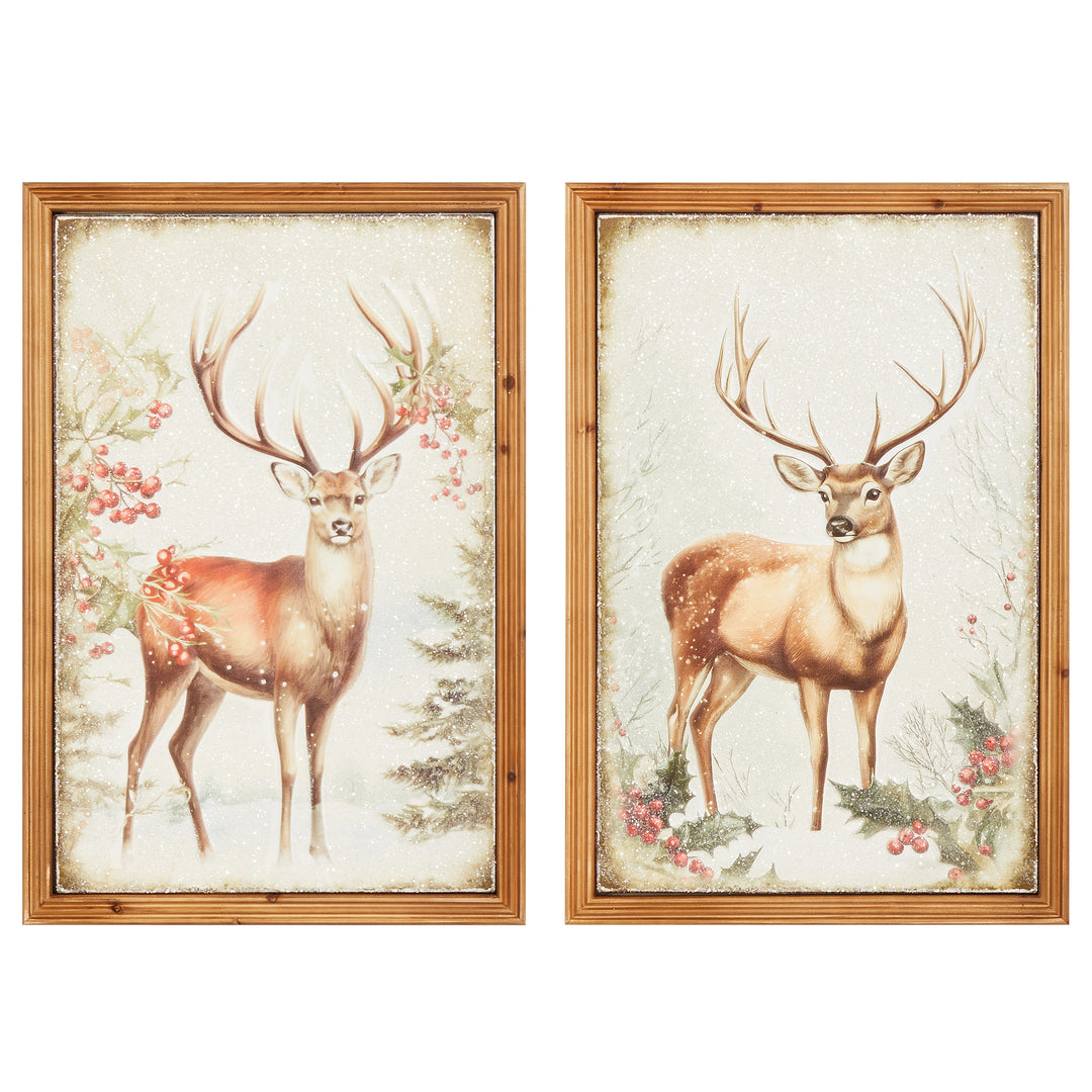 Two framed metal wall art pieces featuring stags in a snowy winter scene with holly and berries.