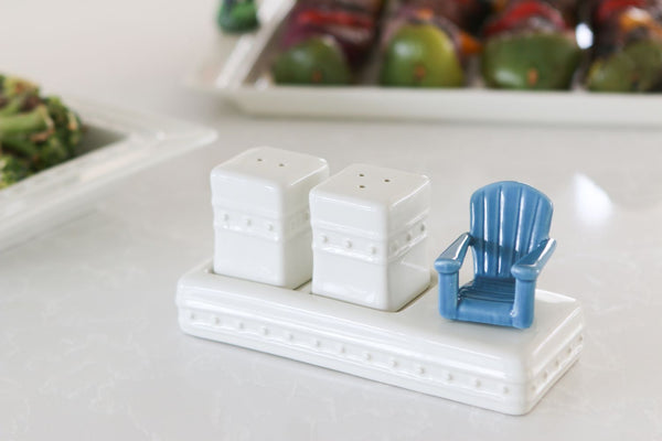 White ceramic salt and pepper shaker set on a matching tray with a small blue Adirondack chair.