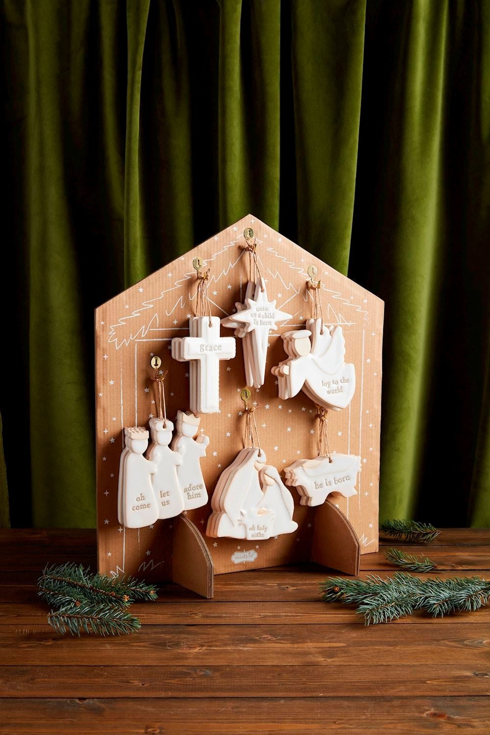 Milk glazed textured stoneware nativity ornament with antique wash finish on kraft stand.