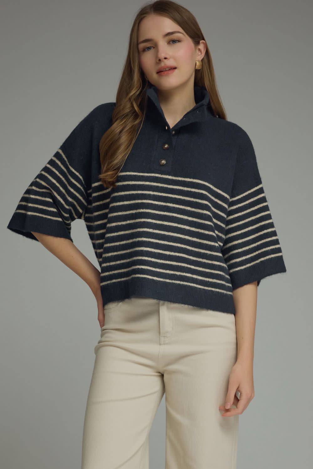 Woman wearing the Charlene Stripe Short Sleeve Knit Top in navy with cream stripes and beige pants.