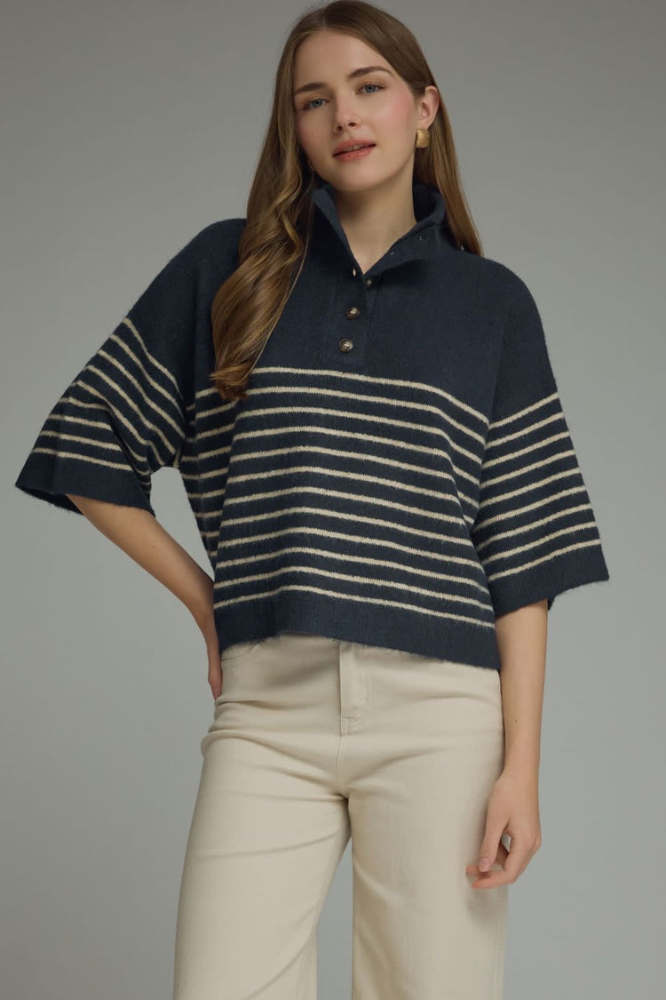 Woman wearing the Charlene Stripe Short Sleeve Knit Top in navy with cream stripes and beige pants.