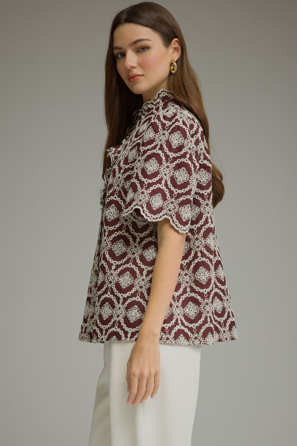 Side view of a woman wearing a burgundy Amalia geometric embroidered short puff sleeve top.
