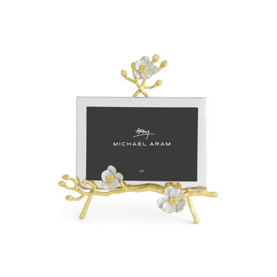 Goldtone easel frame with white enamel glass holding a photo.