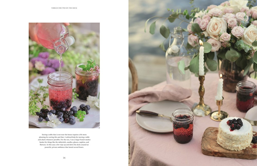 Open pages of French Country Cottage Inspired Gatherings showing a romantic table setting by a lake.