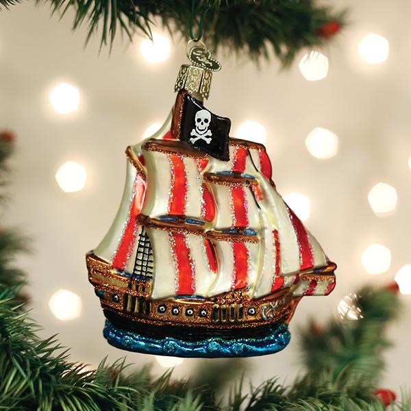 Glass pirate ship ornament with red and white striped sails and a black skull and crossbones flag.