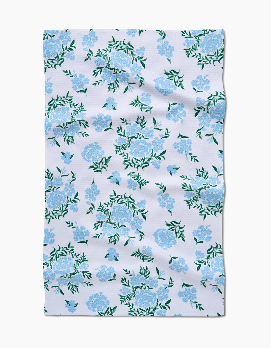 Spring tea towel with waffle weave construction in light green featuring a floral pattern.