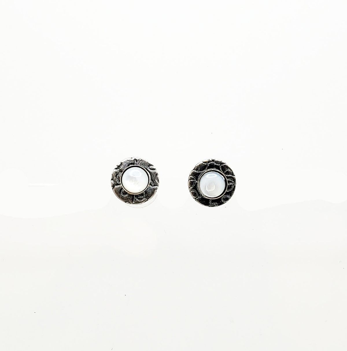 Round framed earrings with mother-of-pearl pierced studs in iridescent white and pink hues.