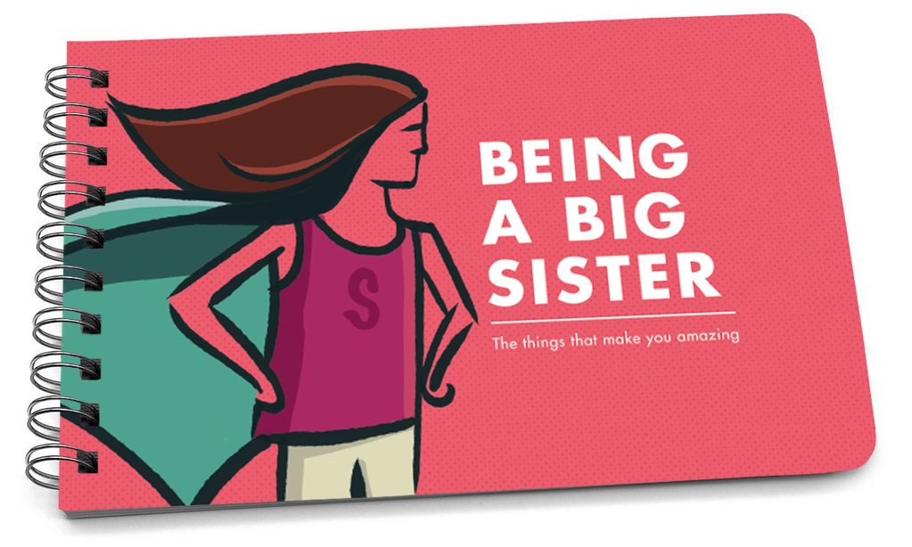 Spiral-bound handbook with a pink cover featuring a cartoon girl in a superhero pose and the text "Being a Big Sister."