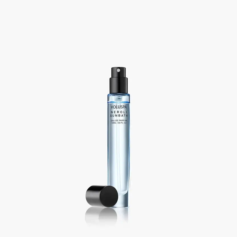 A small glass bottle of Neroli Sunbath Eau De Parfum with a gold cap and clear liquid.