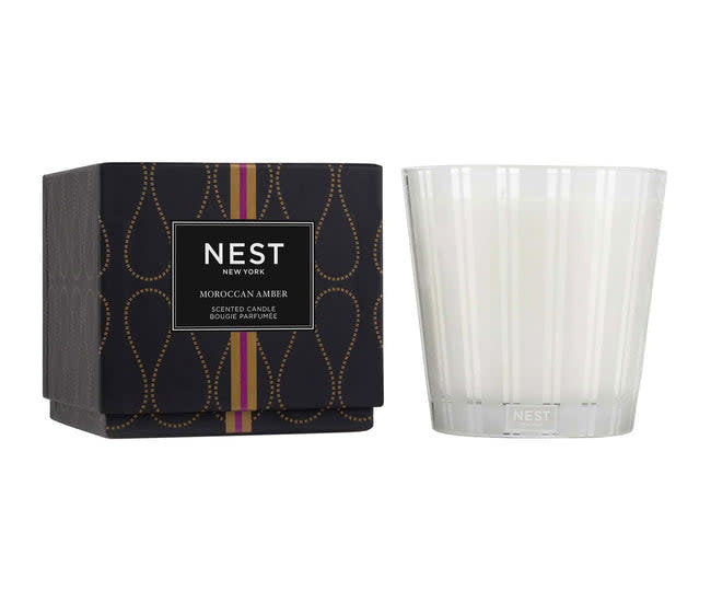 Nest Moroccan Amber three-wick candle in a cylindrical glass jar with a black lid.