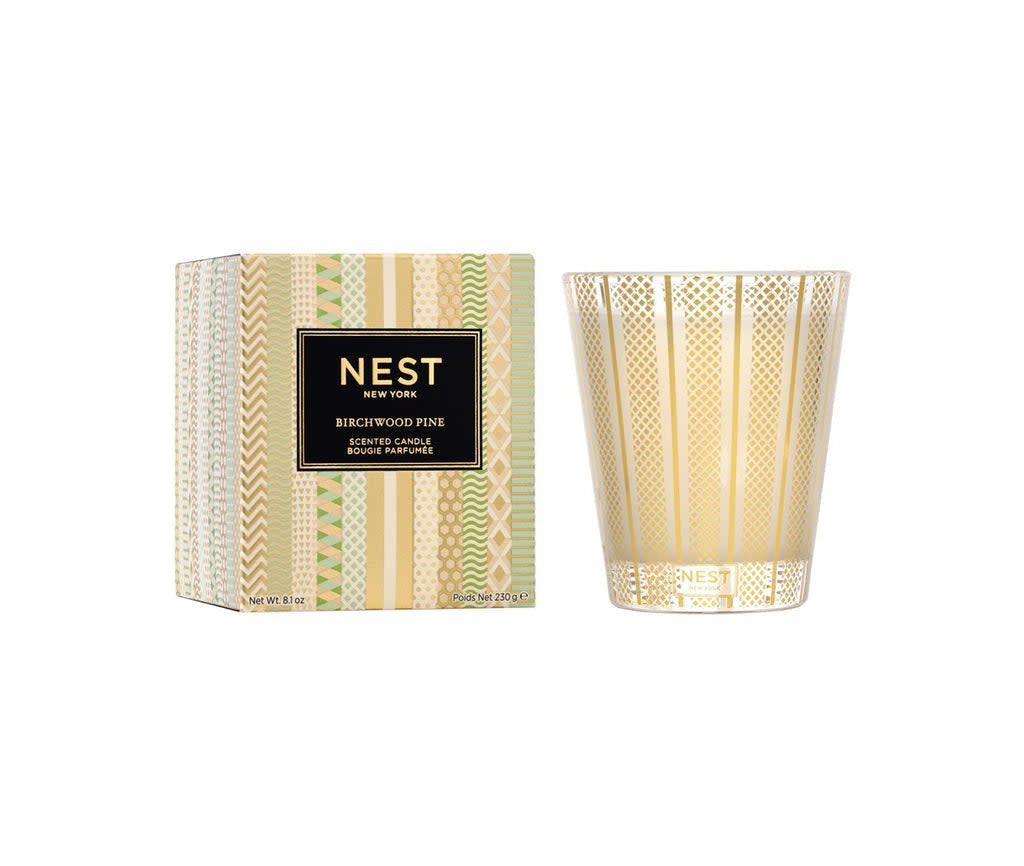 Nest Classic Candle in birchwood pine scent housed in a simple cylindrical glass jar with white wax.