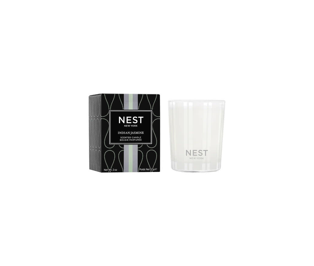 Nest Votive Candle in Indian Jasmine scent with a creamy white wax pool inside a clear glass holder.