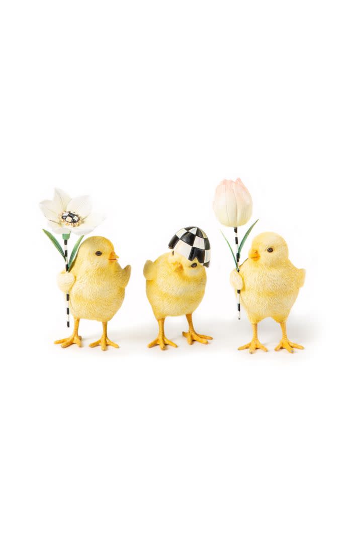 Three yellow resin chicks: one with a white flower, one with a checkered hat, and one with a tulip.