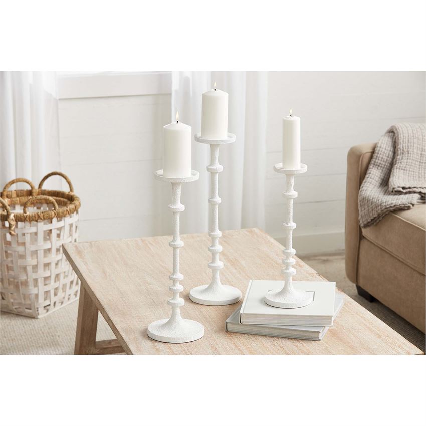 Two white metal candlesticks with a simple cylindrical shape.