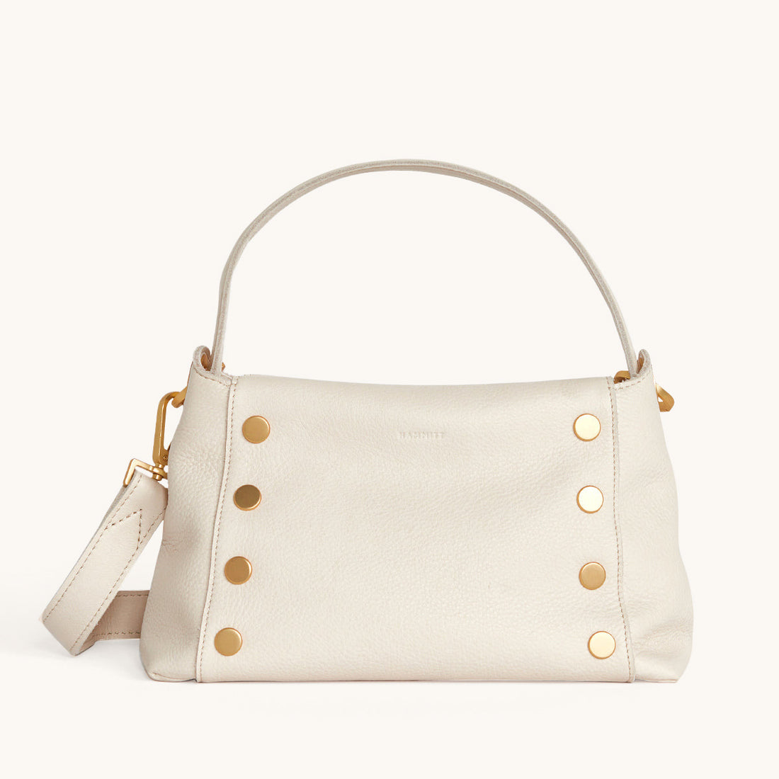 Bryant Med crossbody bag in white Calla Lily exterior with brushed gold hardware and adjustable straps.