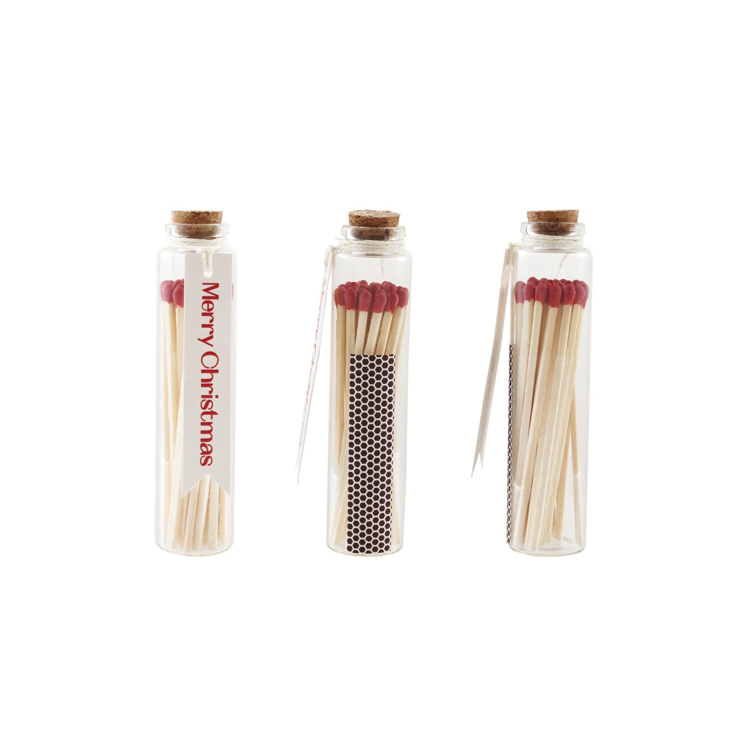 Three glass bottle match holders with cork stoppers, red-tipped matches, and a Merry Christmas tag.