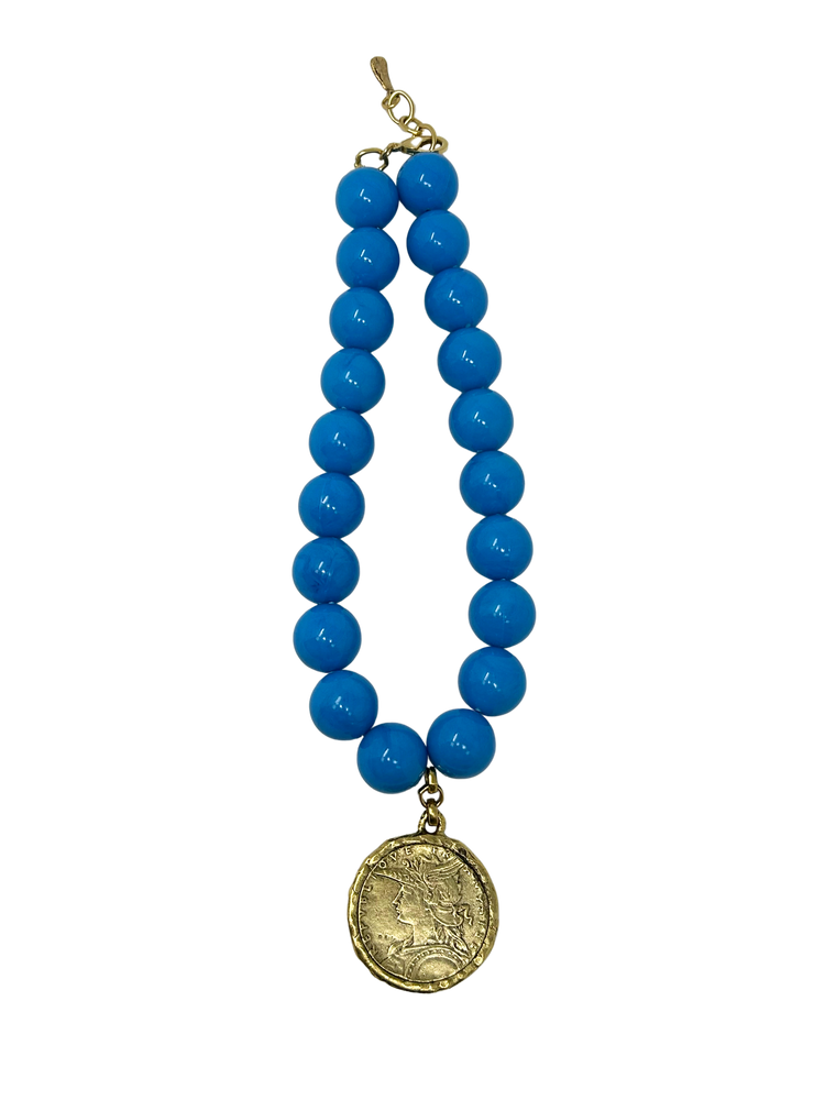 Vintage 18-inch necklace featuring large bright blue beads and a gold-tone coin medallion pendant.