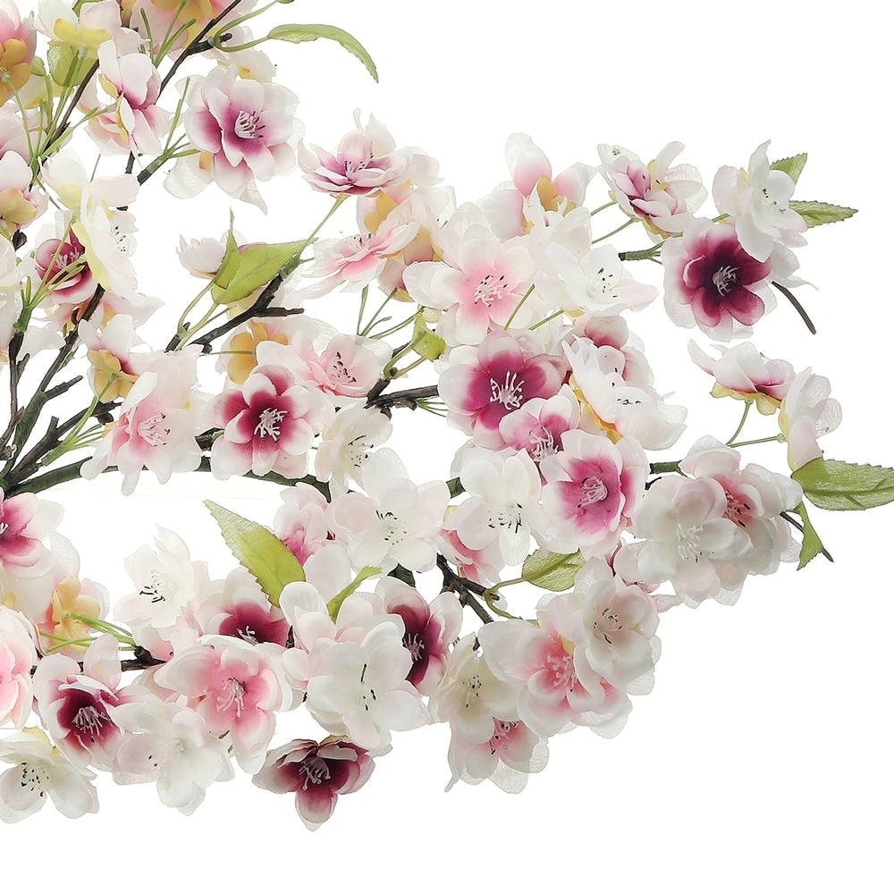 Round cherry blossom wreath with lifelike pink polyester blooms on a white background.