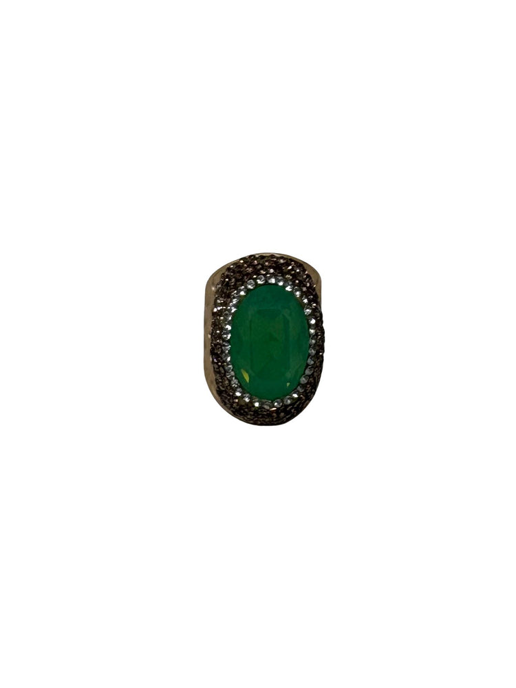 Fashion gemstone ring featuring a large oval green emerald center stone with a textured halo.