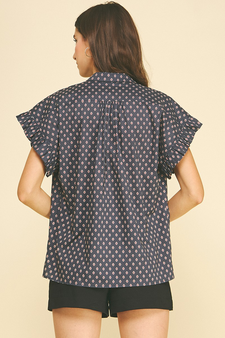 Back view of a navy blue geometric diamond print shirt with ruffled cap sleeves and a classic collar.