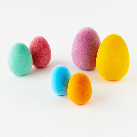White flocked egg-shaped candle with a smooth matte finish.