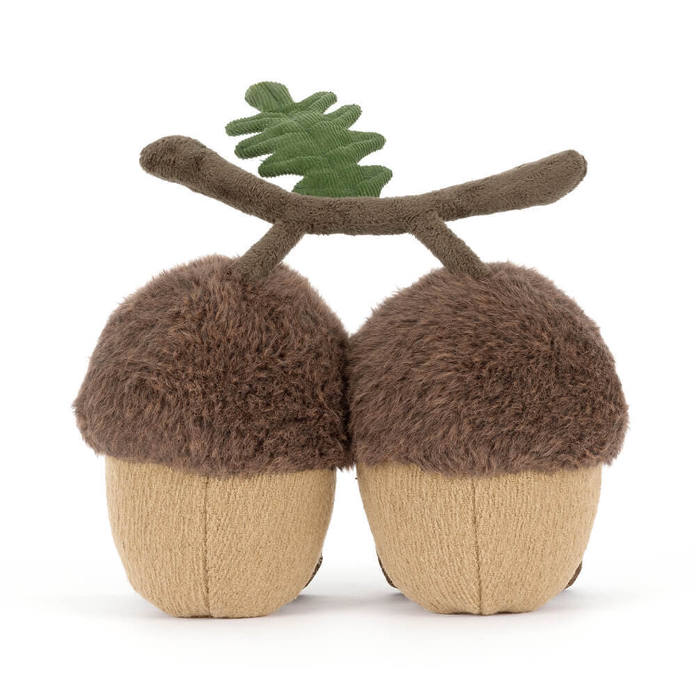Two plush brown and tan acorns joined by a brown stem with a green corduroy leaf.